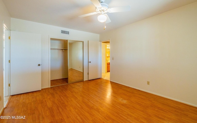 unfurnished bedroom with ceiling fan, a closet, and light wood-type flooring