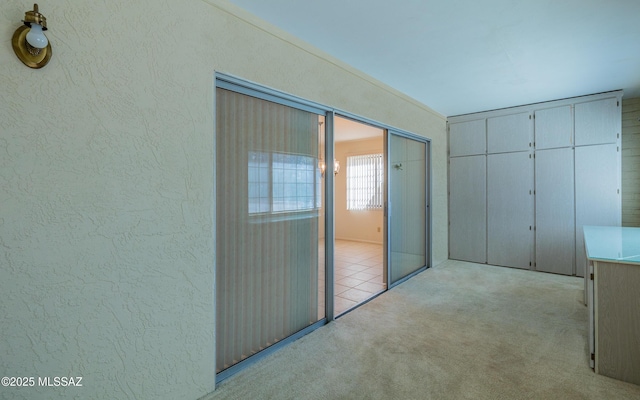 corridor featuring light colored carpet