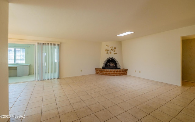 unfurnished living room featuring light tile patterned flooring and a brick fireplace