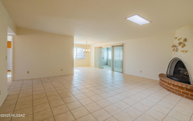 unfurnished living room with light tile patterned flooring and a notable chandelier