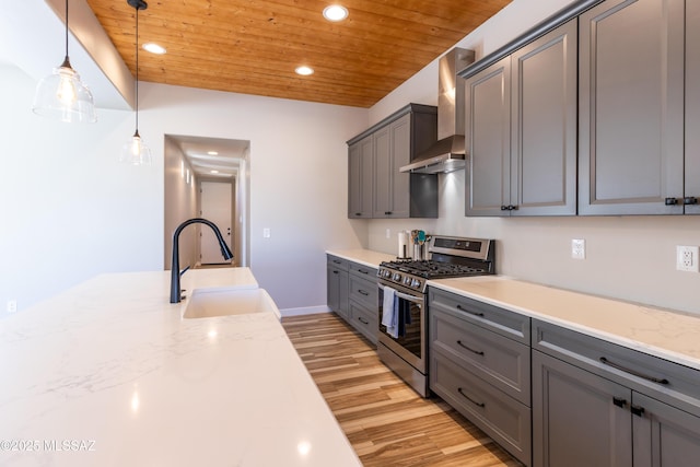 kitchen featuring sink, wooden ceiling, wall chimney range hood, stainless steel gas range oven, and pendant lighting