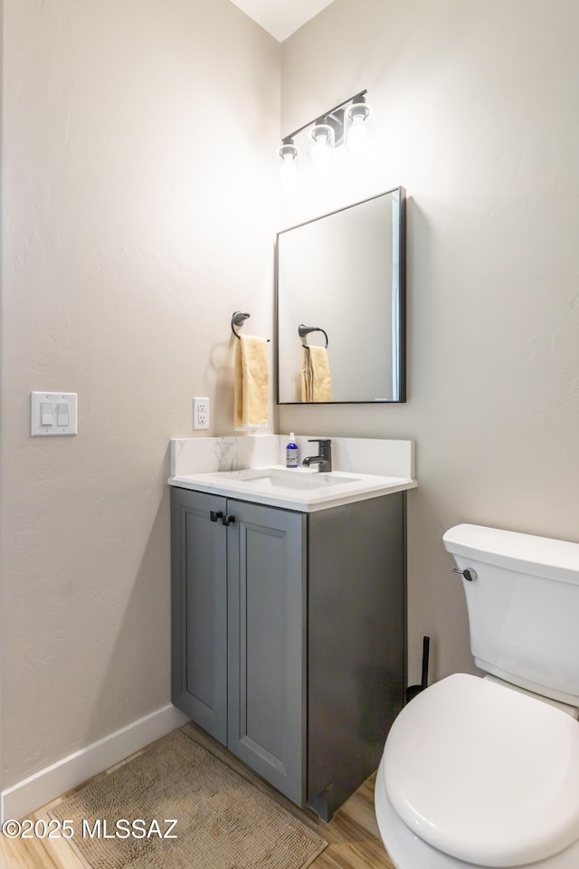 bathroom featuring wood-type flooring, vanity, and toilet