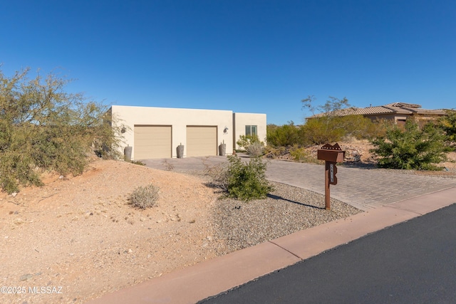 pueblo revival-style home featuring a garage