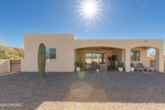 back of property with ceiling fan, a patio, and an outdoor living space