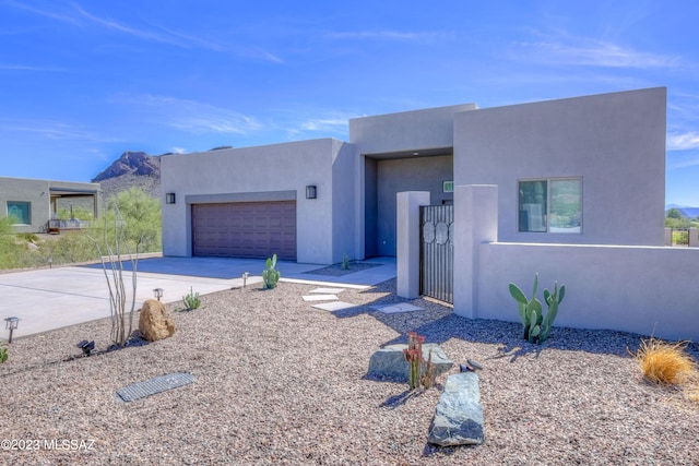 pueblo-style house featuring a mountain view and a garage