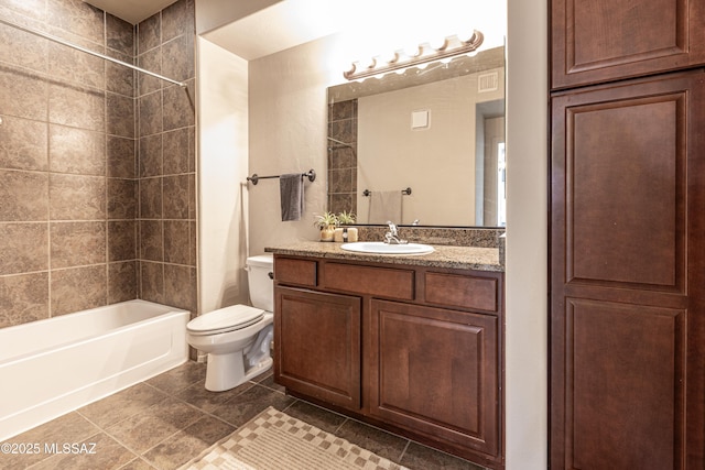 full bathroom featuring vanity, tiled shower / bath combo, and toilet