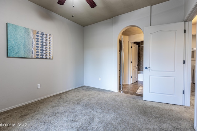 carpeted spare room featuring ceiling fan