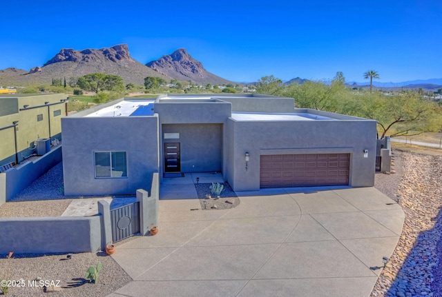 view of front of property with a mountain view, cooling unit, and a garage