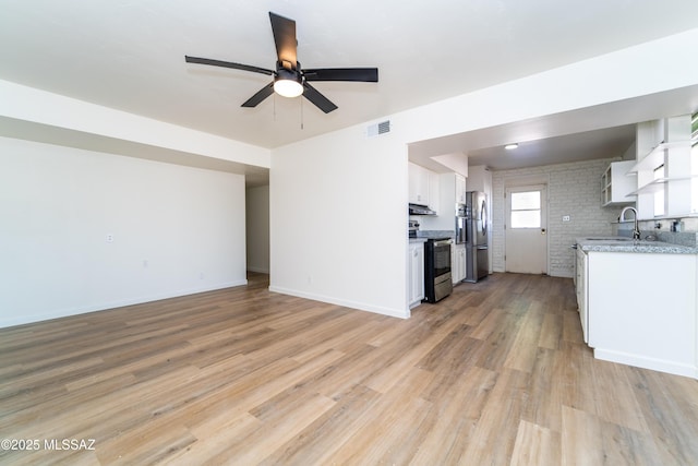 unfurnished living room featuring ceiling fan, sink, and light hardwood / wood-style floors