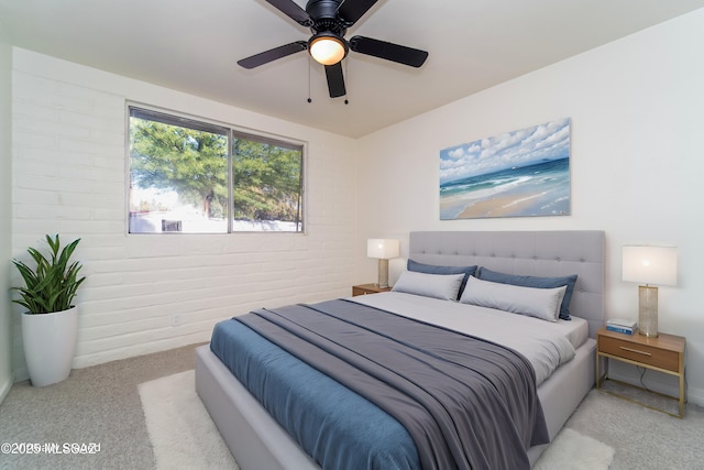 bedroom with brick wall, light colored carpet, and ceiling fan