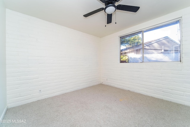 carpeted empty room with brick wall