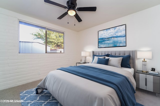 carpeted bedroom featuring brick wall and ceiling fan