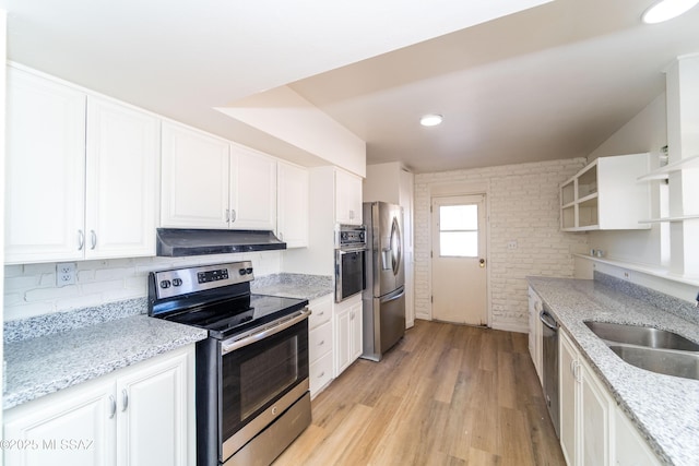 kitchen with light stone countertops, appliances with stainless steel finishes, sink, and white cabinets