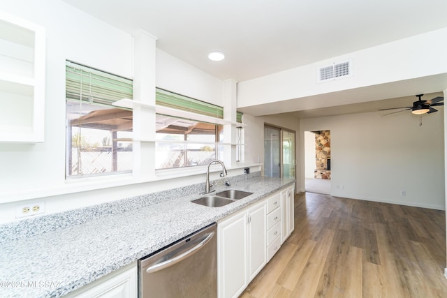 kitchen featuring white cabinetry, sink, stainless steel dishwasher, light stone counters, and light wood-type flooring