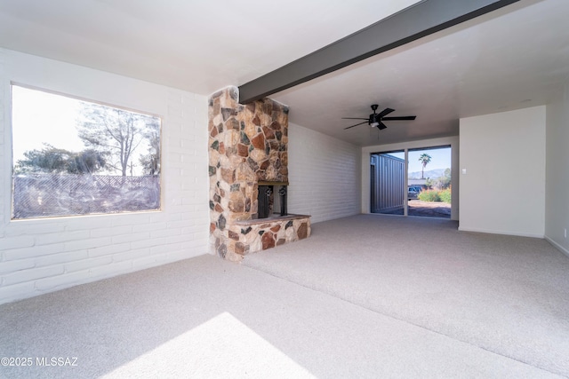 unfurnished living room featuring lofted ceiling with beams, ceiling fan, carpet flooring, and a fireplace