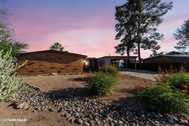 back house at dusk with a carport