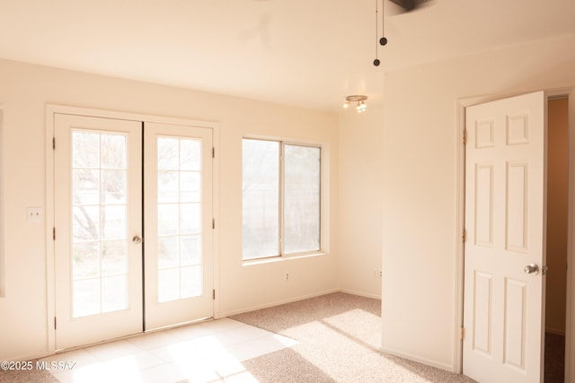 entryway featuring french doors, light colored carpet, and plenty of natural light