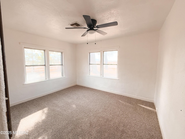 unfurnished room with carpet flooring, ceiling fan, and a textured ceiling