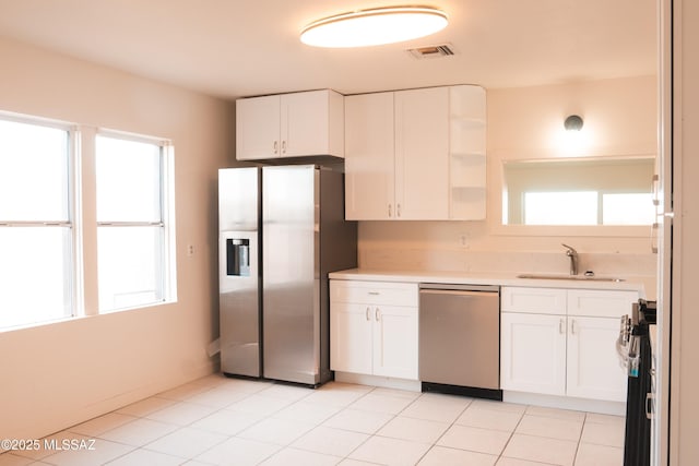 kitchen featuring a wealth of natural light, white cabinetry, sink, and appliances with stainless steel finishes