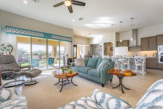 living room with ceiling fan with notable chandelier