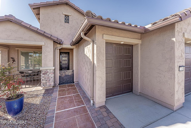 doorway to property featuring a garage and a patio