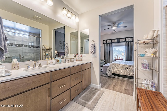 bathroom featuring ceiling fan, a shower with door, hardwood / wood-style flooring, and vanity