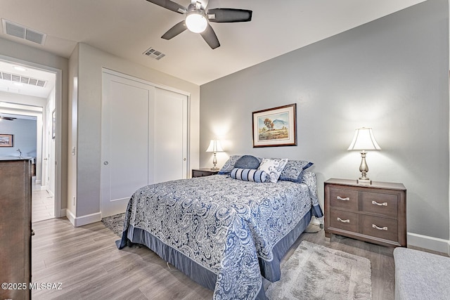 bedroom featuring ceiling fan, a closet, and light hardwood / wood-style floors