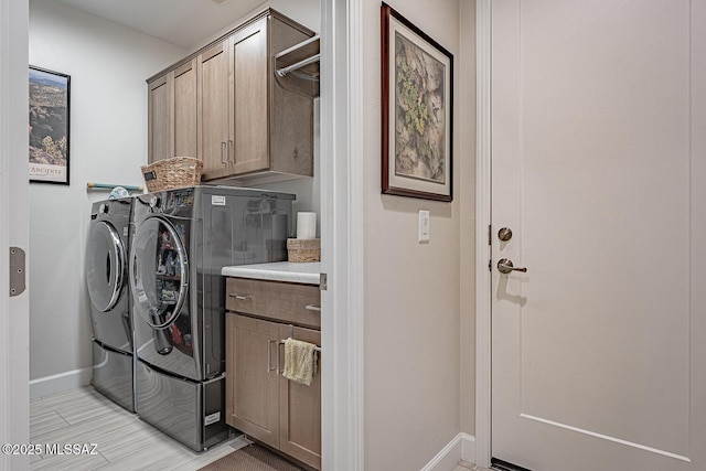 laundry room featuring washer and clothes dryer and cabinets