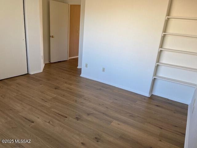 unfurnished bedroom with a closet and dark wood-type flooring