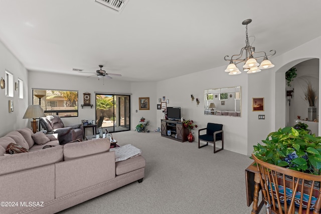 living area featuring carpet floors, visible vents, arched walkways, and ceiling fan with notable chandelier