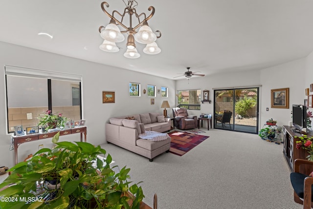 living room featuring carpet flooring and ceiling fan with notable chandelier