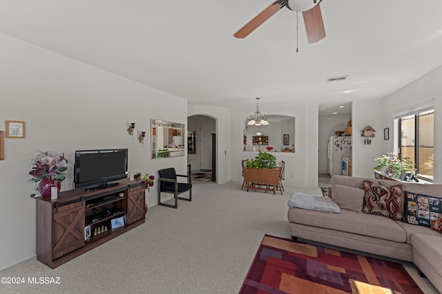 living room with arched walkways, ceiling fan with notable chandelier, visible vents, and carpet