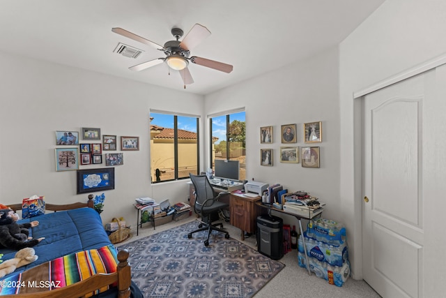 carpeted home office featuring a ceiling fan and visible vents