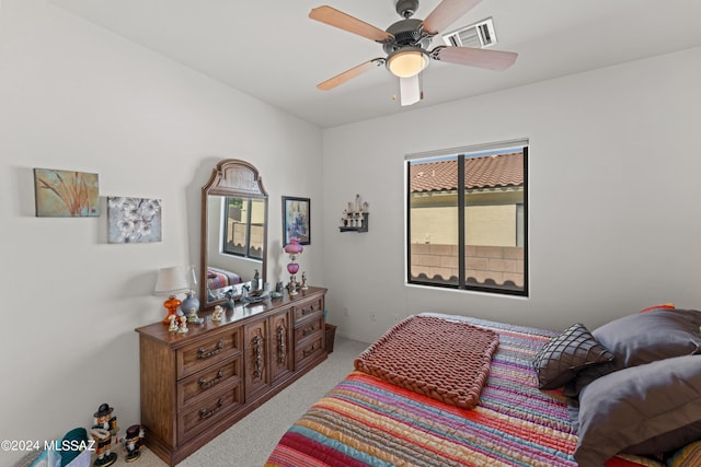 carpeted bedroom with a ceiling fan and visible vents