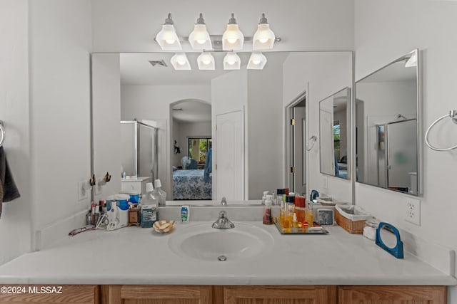 bathroom with ensuite bath, a shower stall, and vanity