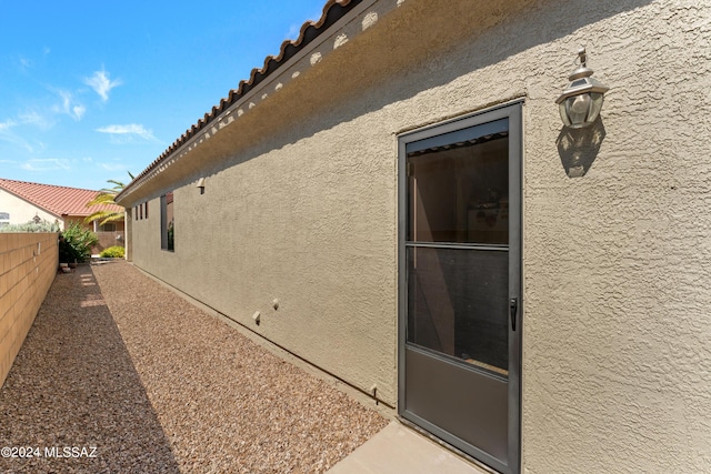 view of side of property with fence and stucco siding