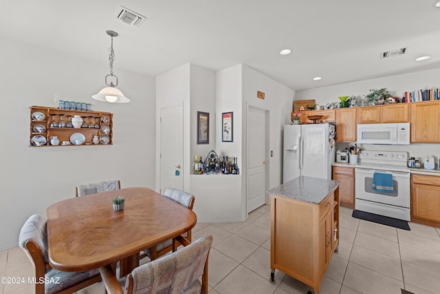 kitchen with white appliances, light tile patterned flooring, visible vents, and decorative light fixtures