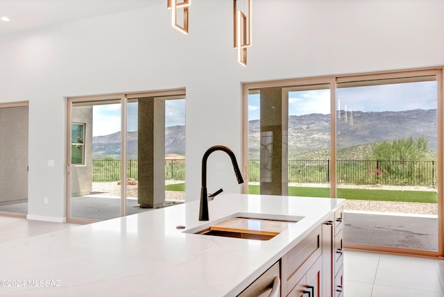 14821 E Diamond F Rnch Pl, Vail, AZ 85641 - kitchen featuring a mountain view, light tile patterned floors, a sink, light stone countertops, and a towering ceiling
