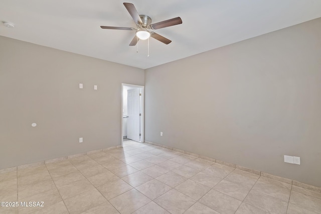 spare room with ceiling fan and light tile patterned floors