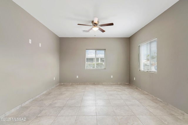 spare room with ceiling fan and light tile patterned floors