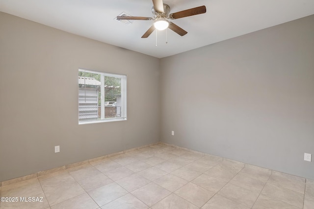 empty room with ceiling fan and light tile patterned floors