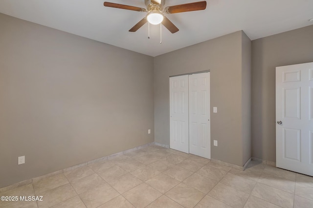 unfurnished bedroom with light tile patterned floors, a closet, and ceiling fan