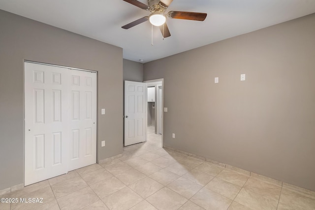 unfurnished bedroom with ceiling fan, light tile patterned floors, and a closet