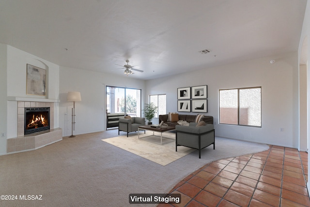 carpeted living room featuring ceiling fan and a tiled fireplace