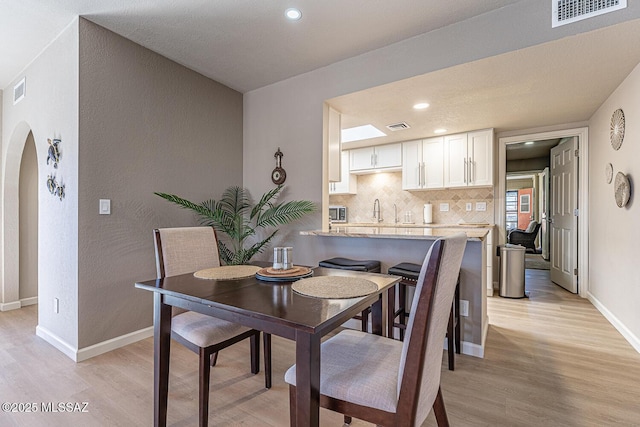 dining space with light hardwood / wood-style floors and sink