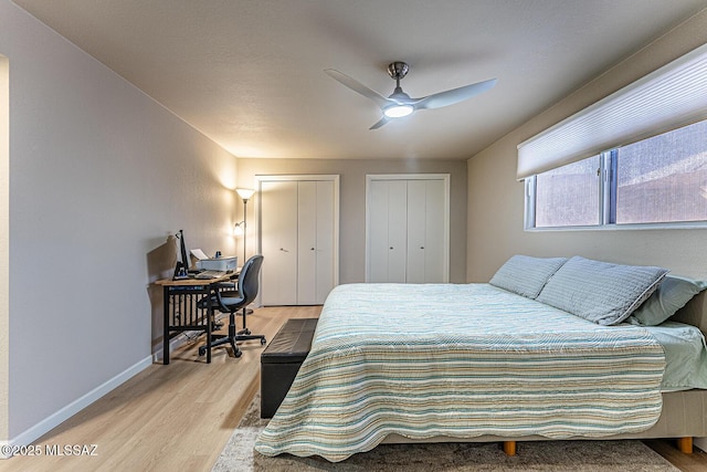 bedroom featuring multiple closets, ceiling fan, and light hardwood / wood-style floors