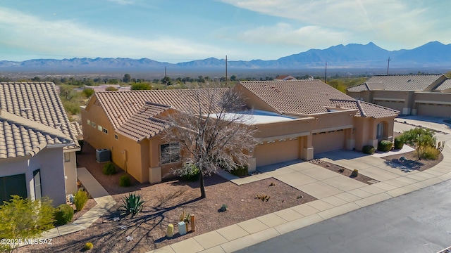 exterior space with a garage, central AC, and a mountain view