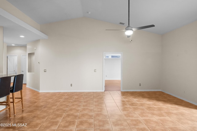 tiled spare room featuring ceiling fan and high vaulted ceiling