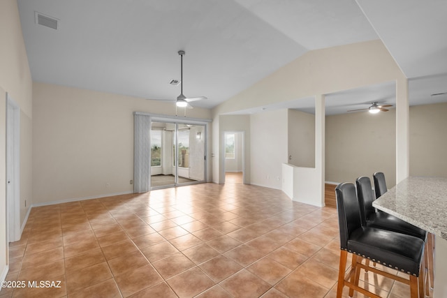 tiled living room with ceiling fan and vaulted ceiling