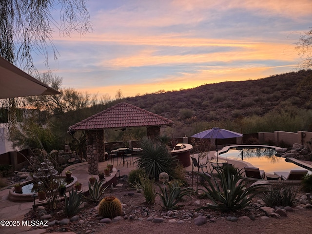 exterior space featuring a fenced in pool, a patio, and a gazebo